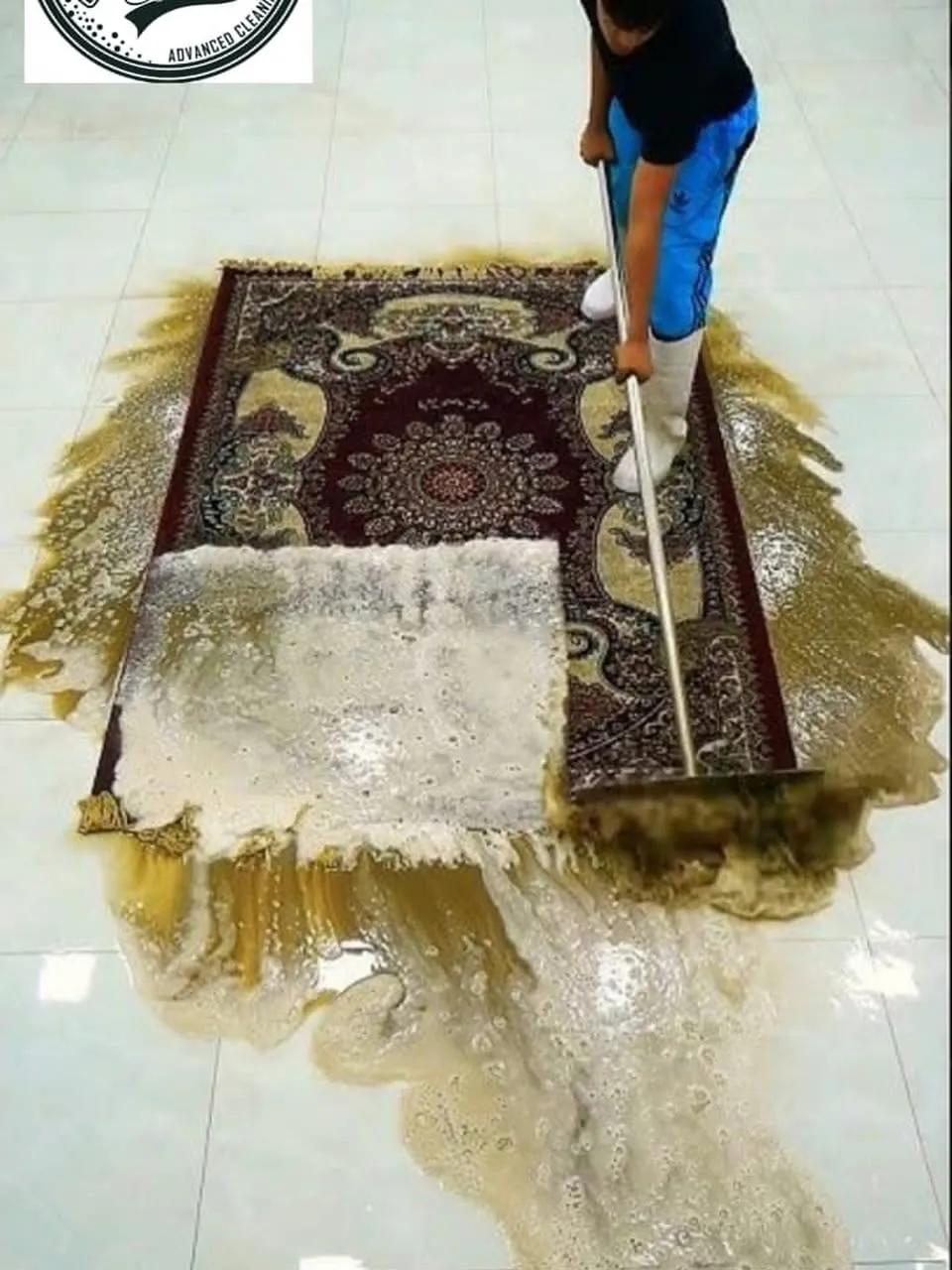 عامل يغسل سجادة بالرغوة في مغسلة سجاد الاتحاد